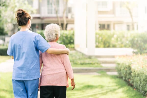 asistente sociosanitaria ayudando a anciana