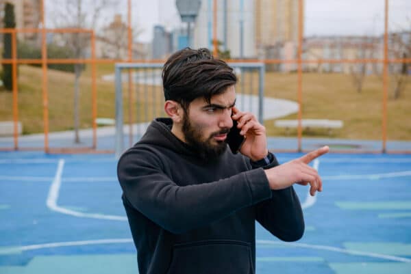 hombre con teléfono en pista deportiva
