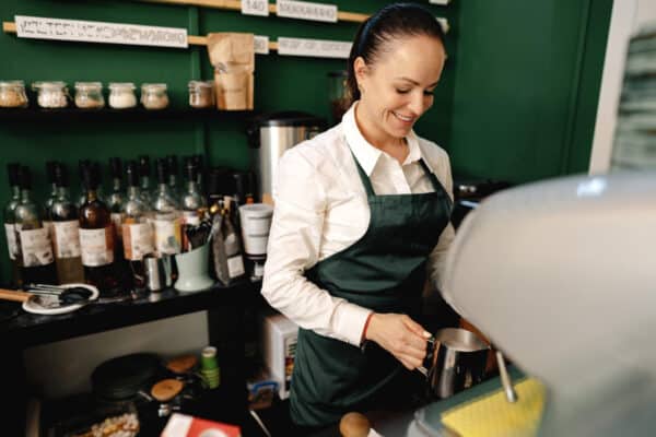 camarera en cafetera haciendo café