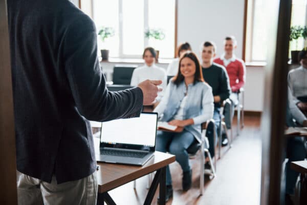 docente de espaldas con clase sentada