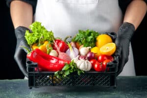 Manos con caja de verduras