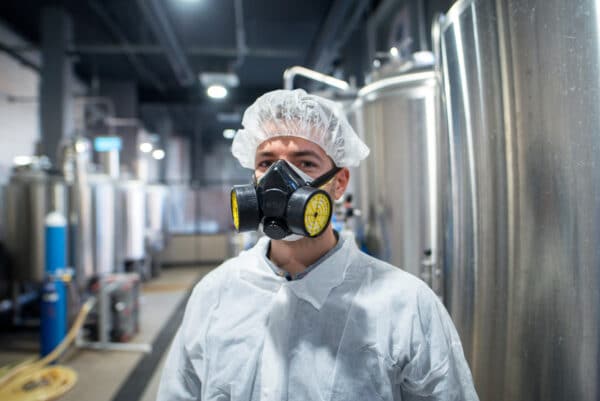 hombre con máscara de gas en fábrica
