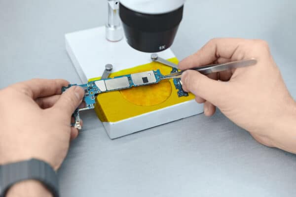 manos arreglando microchip