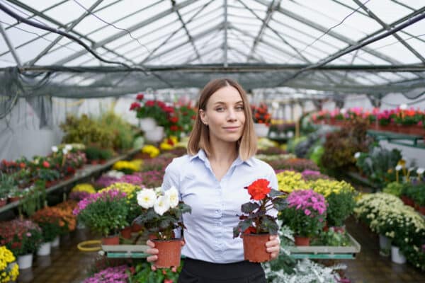 mujer con flores sonriendo en vivero