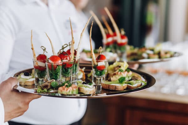 manos con bandeja catering
