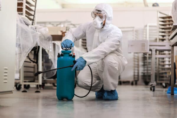 hombre con epi y bombona de fumigar